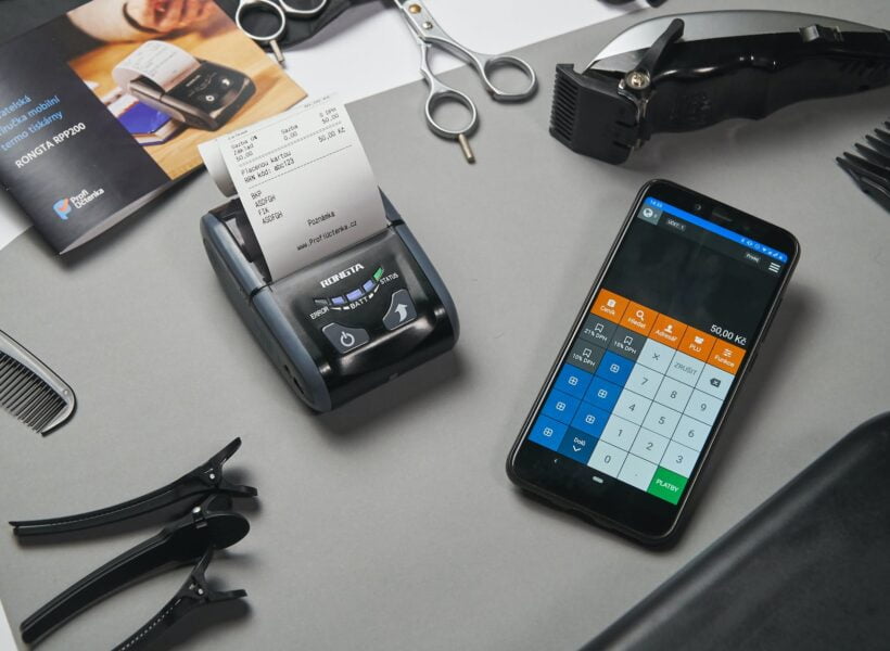 cash register and calculator on smartphone in barber shop