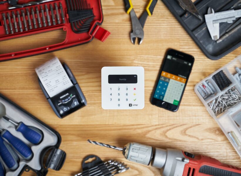 smartphone and cash registers surrounded by tools